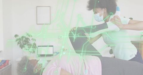 Physiotherapist assisting leg stretch with neon circuit overlay, digital rehab concept