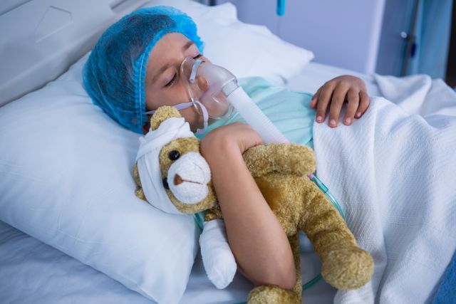 Patient with oxygen mask relaxing on bed in ward at hospital
