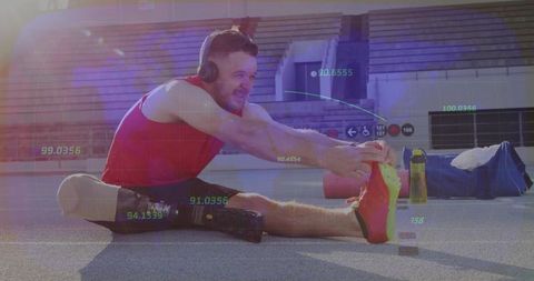 Athlete with prosthetic leg stretching on stadium track