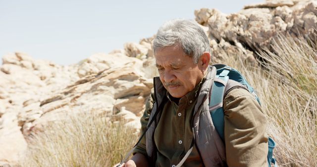 Senior Man Enhancing Outdoor Adventures Reading Map in Rocky Desert - Download Free Stock Images Pikwizard.com