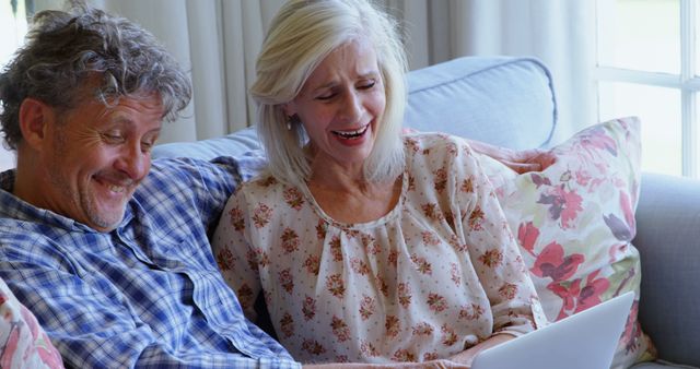 Smiling Senior Couple Using Digital Tablet on Couch at Home - Download Free Stock Images Pikwizard.com