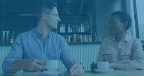 Two Friends Enjoying Coffee and Conversation in a Cozy Cafe Setting