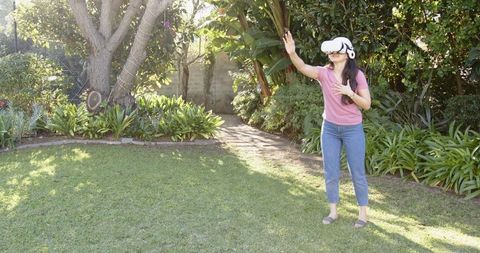 Woman experiencing vr technology in peaceful garden setting