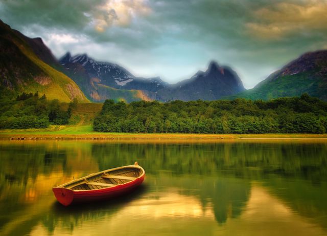 Rowboat floating on a calm lake at sunset with mountains and evergreen forest reflecting in still water. Perfect for designs focusing on tranquility, solitude, natural beauty, and escape to serene locations. Ideal for travel brochures, nature websites, and relaxation content.
