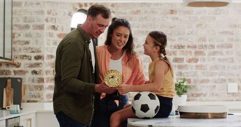 Family Celebrating Football Success in Kitchen Setting