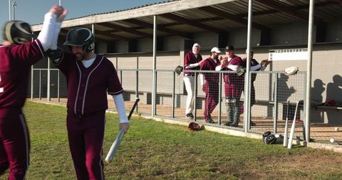Baseball Team Celebrating Win with High Fives on the Field
