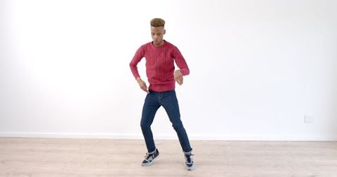 Man Dancing Energetically Indoors in Casual Outfit