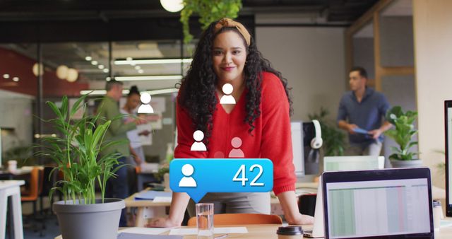 Image of profile icon with increasing numbers over biracial woman smiling at office. Social media networking and business technology concept