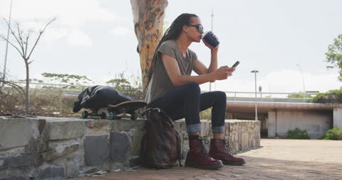 Youthful Skater Relaxing with Coffee and Smartphone