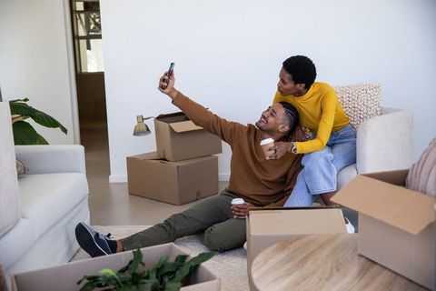 Diverse Couple Taking Selfie While Unpacking in New Home