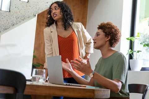 Diverse Female Colleagues Brainstorming Around Laptop in Office