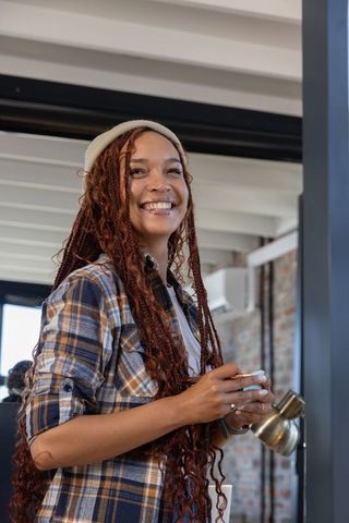 Joyful Woman in Workplace Holding Coffee