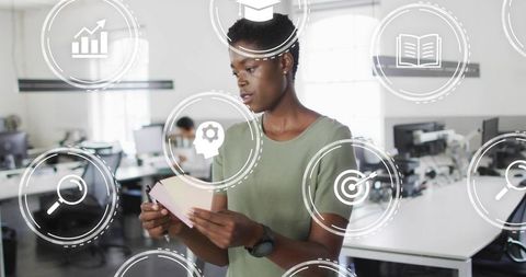 Professional woman using sticky notes with augmented reality icons in modern workspace