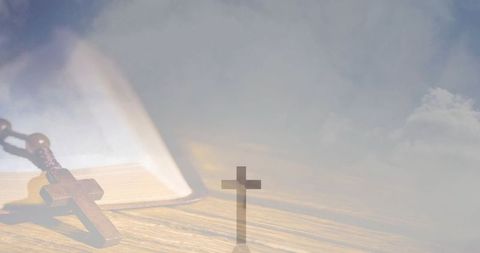 Wooden rosary resting on open bible with cross silhouette and soft morning light