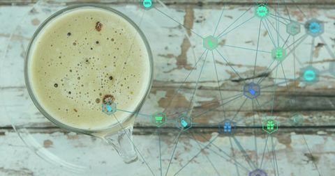 Top-down glass coffee cup on weathered wood with teal retail network overlay and copy space