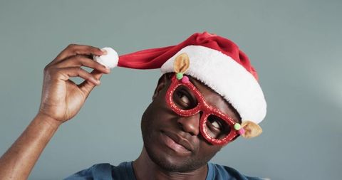 Cheerful man with santa hat and festive glasses celebrates holiday spirit