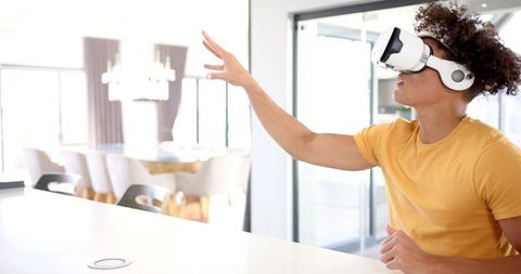 Young Man Using VR Headset in Modern Kitchen Environment