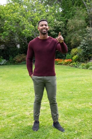 Man Enjoying Nature in Garden Pointing Towards Flower Bed