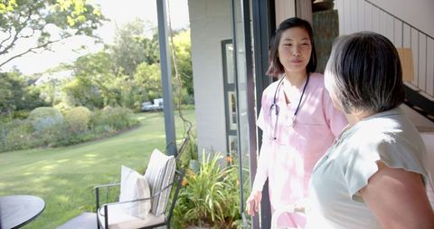 Physiotherapist Assisting Senior Asian Woman at Home Garden