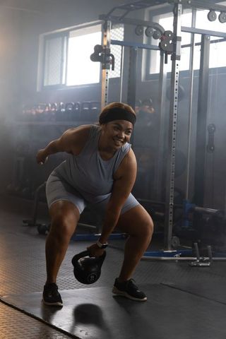 African american woman performing kettlebell swing, strength training and fitness lifestyle