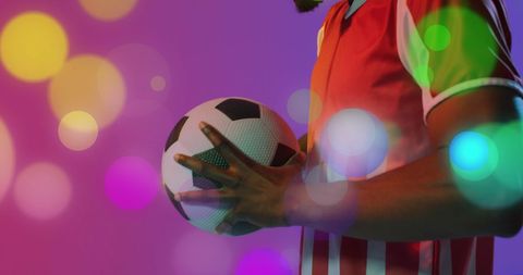 Soccer Player Holding Ball with Colorful Spotlights - Download Free Stock Images Pikwizard.com