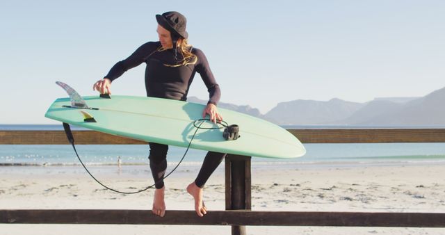 Female surfer checking her surfboard at beach - Download Free Stock Images Pikwizard.com