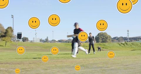 Energetic youth batter running with cricket bat on community oval with smiley overlay