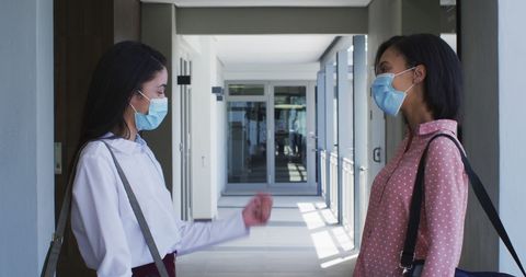 Businesswomen in Face Masks having Discussion Indoors