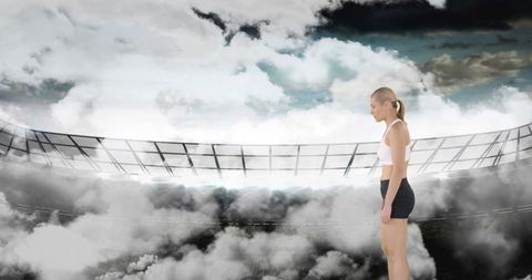 Athletic Woman Standing in Scenic Stadium Surrounded by Dramatic Clouds