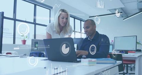 Collaborating on data analytics dashboard in modern open-plan office with digital overlays