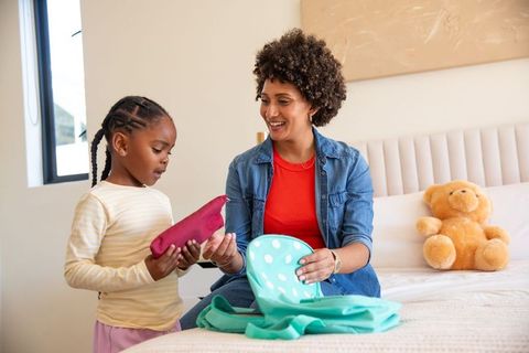 Mother and daughter packing backpack for school together