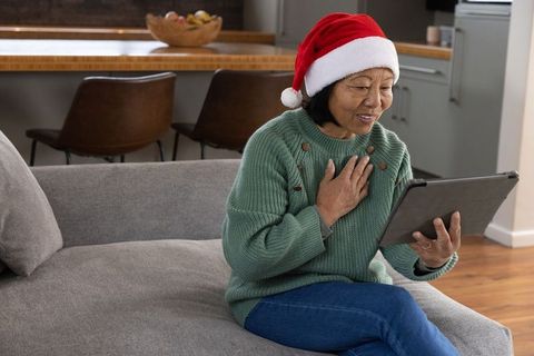Senior Asian Woman Celebrating Holiday with Tablet in Contemporary Home