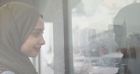 Smiling Woman in Hijab Gazing Out Over Cityscape