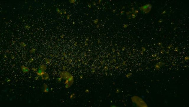 Radiant Green-Gold Orbs in Cosmic Darkness