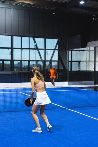 Padel players competing on indoor blue court