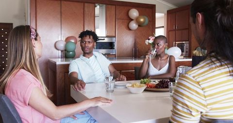 Friends Enjoying Home Party with Snacks and Drinks in Modern Kitchen