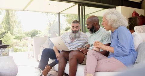 Senior Friends Sharing Laughter and Learning with Laptop
