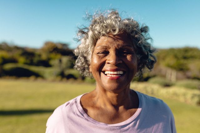 Close-up portrait of cheerful african american senior woman in yard against clear sky in summer. Copy space, nature, nursing home, unaltered, support, assisted living and retirement concept.