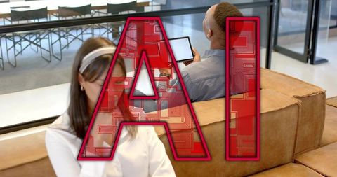 Coworkers sitting on tan sofa using tablet with red ai circuit overlay for workspace