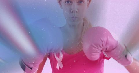 Female Boxer Wearing Pink Gloves Punching Forward with Breast Cancer Awareness Ribbon