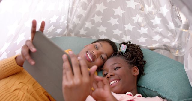 Mother and Daughter Smiling While Using Tablet Inside Cozy Fort - Download Free Stock Images Pikwizard.com