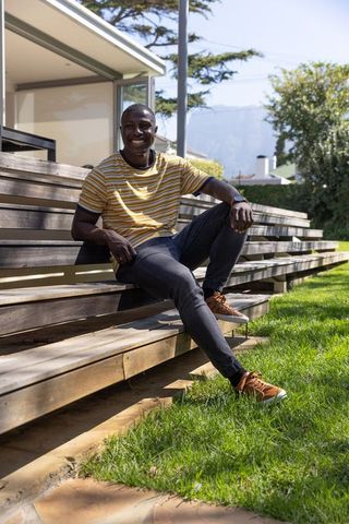 Young man relaxing on outdoor bench in casual attire