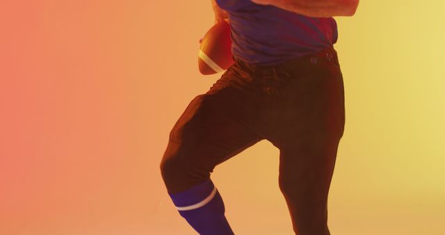 Athletic Football Player Holding Ball in Action Pose on Colorful Gradient Background - Download Free Stock Images Pikwizard.com