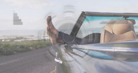 Relaxing barefoot legs dangling from convertible on coastal road with digital hud overlay