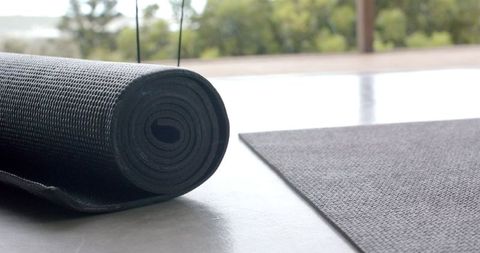 Rolled yoga mat on floor inviting relaxation and fitness