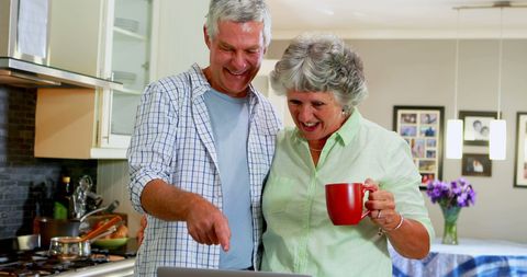 Senior Couple Enjoying Technology in Cozy Kitchen