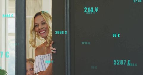 Playful mother and daughter peeking playfully at doorway in modern home