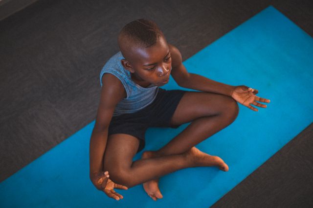 Young African American Boy Meditating on Blue Yoga Mat - Download Free Stock Photos Pikwizard.com