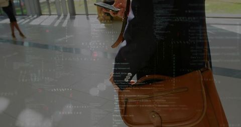 Businessman checking smartphone with overlay of code at modern station