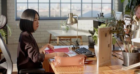 Asian woman working at desk in modern open office